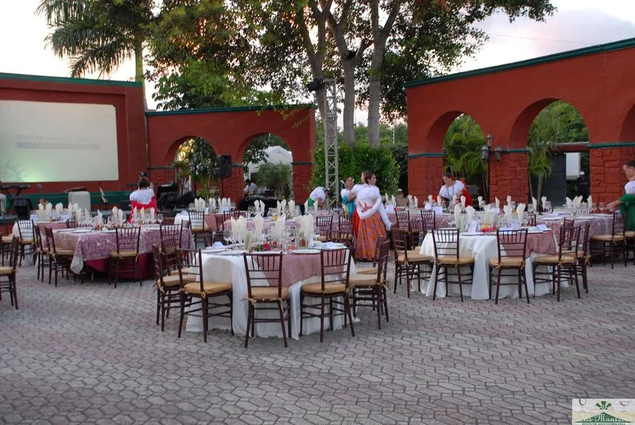 Banquete en patio de hacienda con sillas crossback