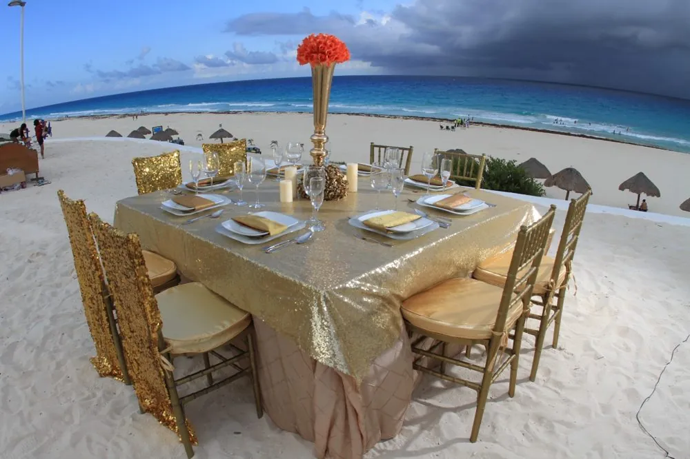 Mantel dorado en la playa con centro de mesa alto